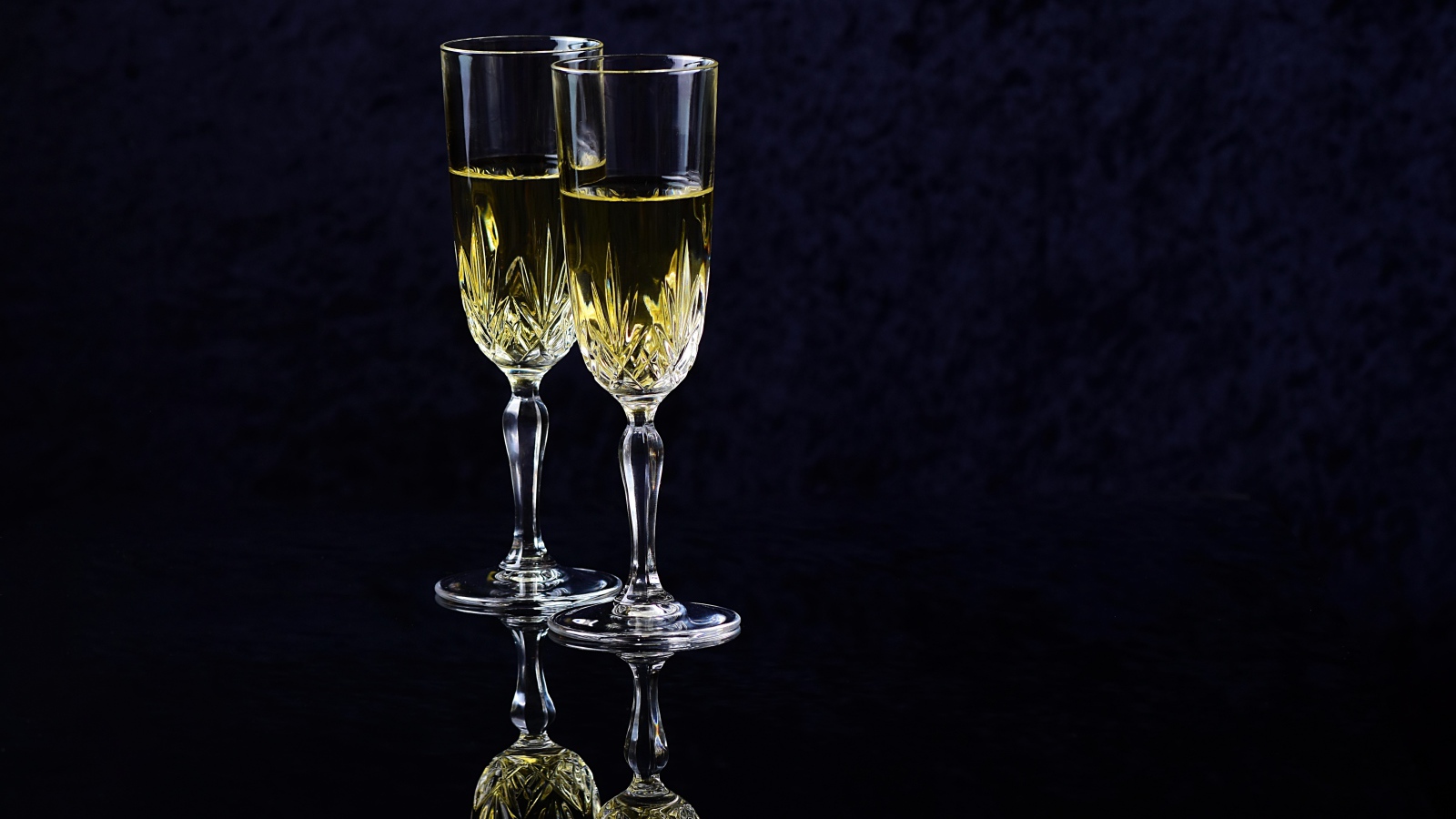 Два бокала с шампанский на черном фоне