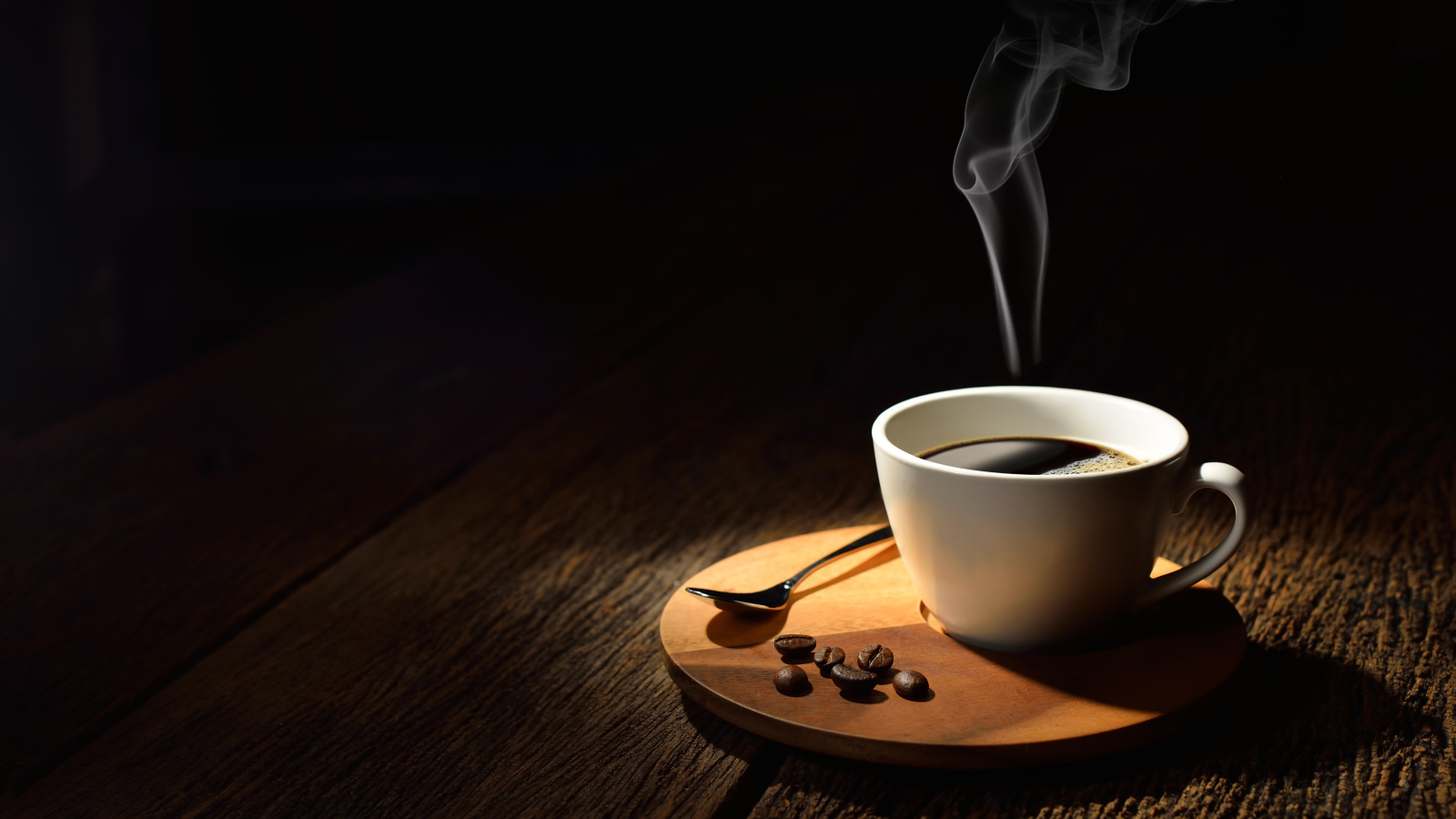 Белая чашка горячего крепкого кофе на столе