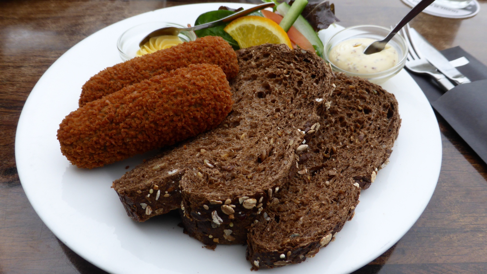 Два куска черного хлеба на тарелке с котлетами