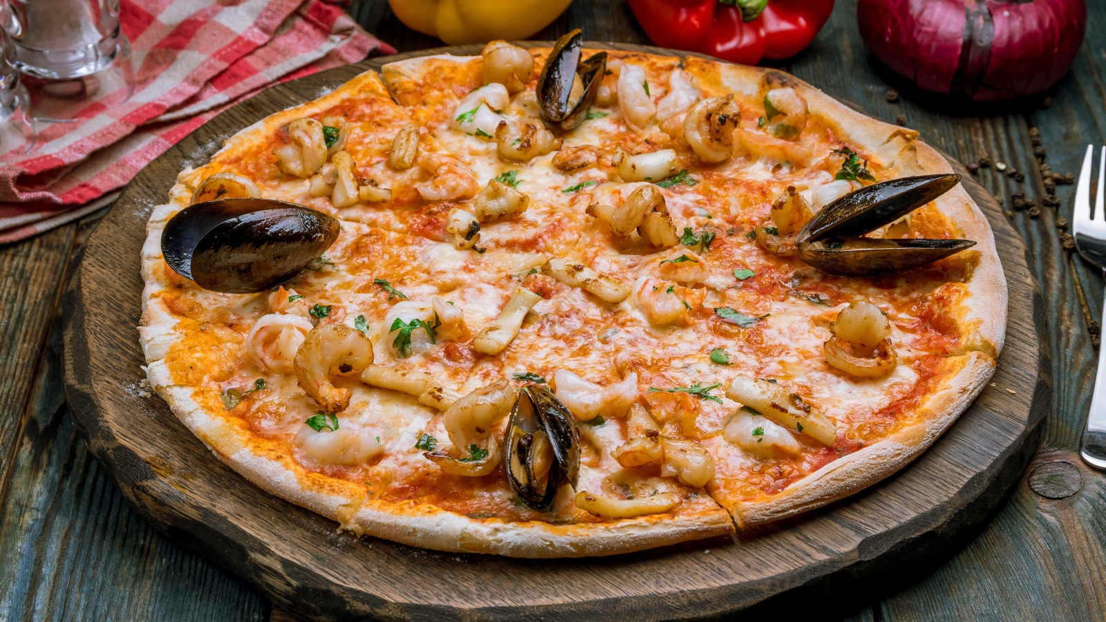 Вкусная пицца с морепродуктами на деревянной доске