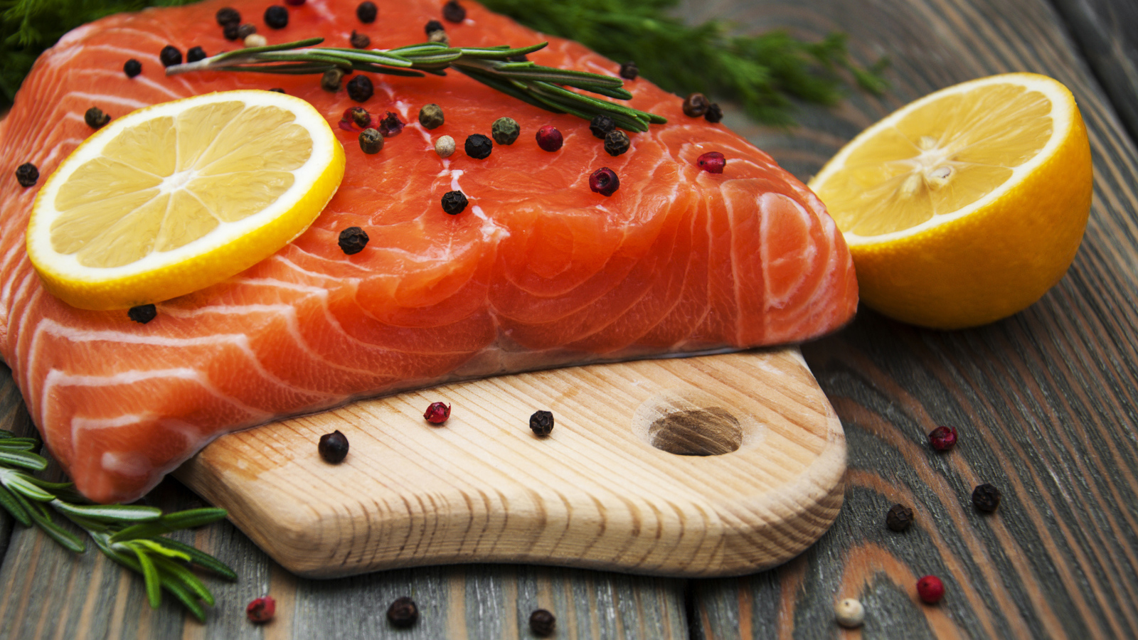 Кусок красной рыбы с лимоном и черным перцем