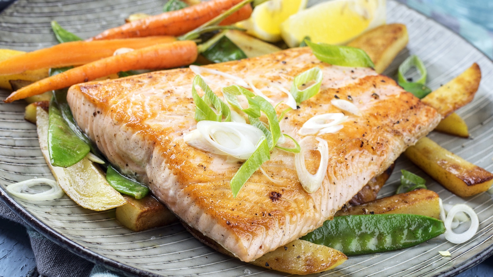 Запеченная красная рыба с овощами на тарелке