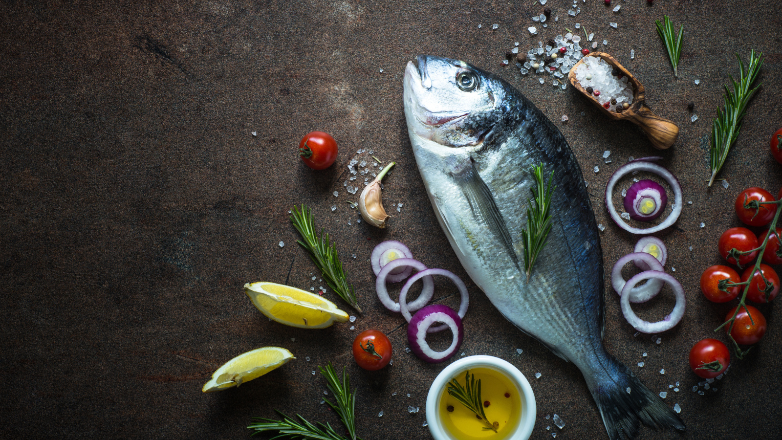 Свежая рыба на столе с овощами и специями 