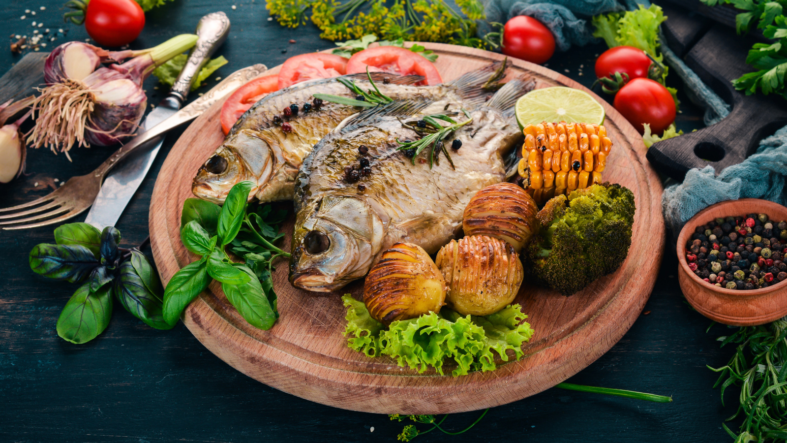 Зажаренная рыба на доске с овощами