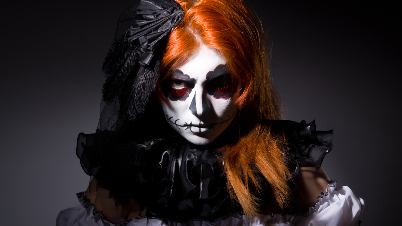 Рыжеволосая девушка с маской на лице на Хэллоуин 