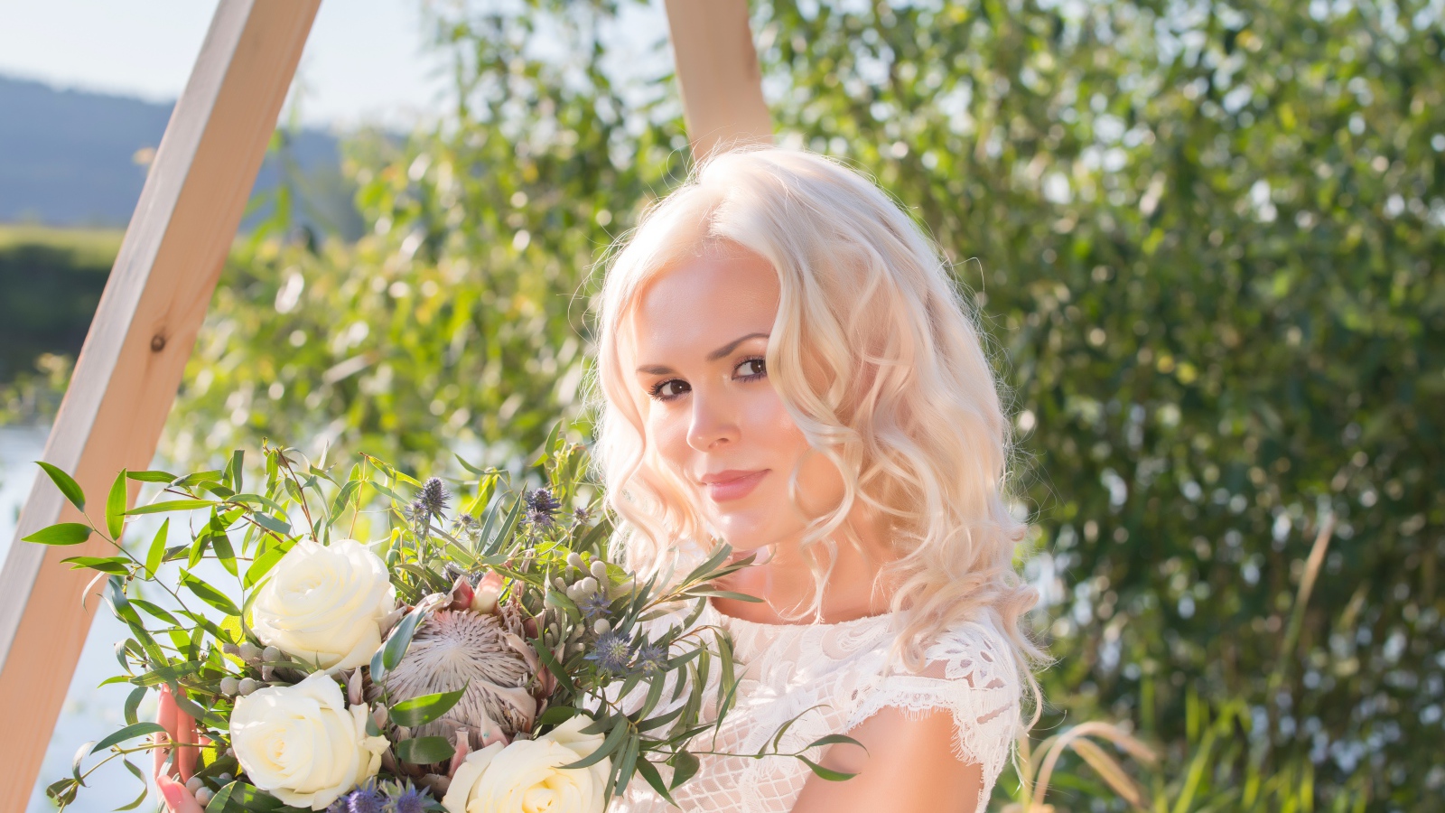 Красивая кареглазая блондинка с букетом в руках 