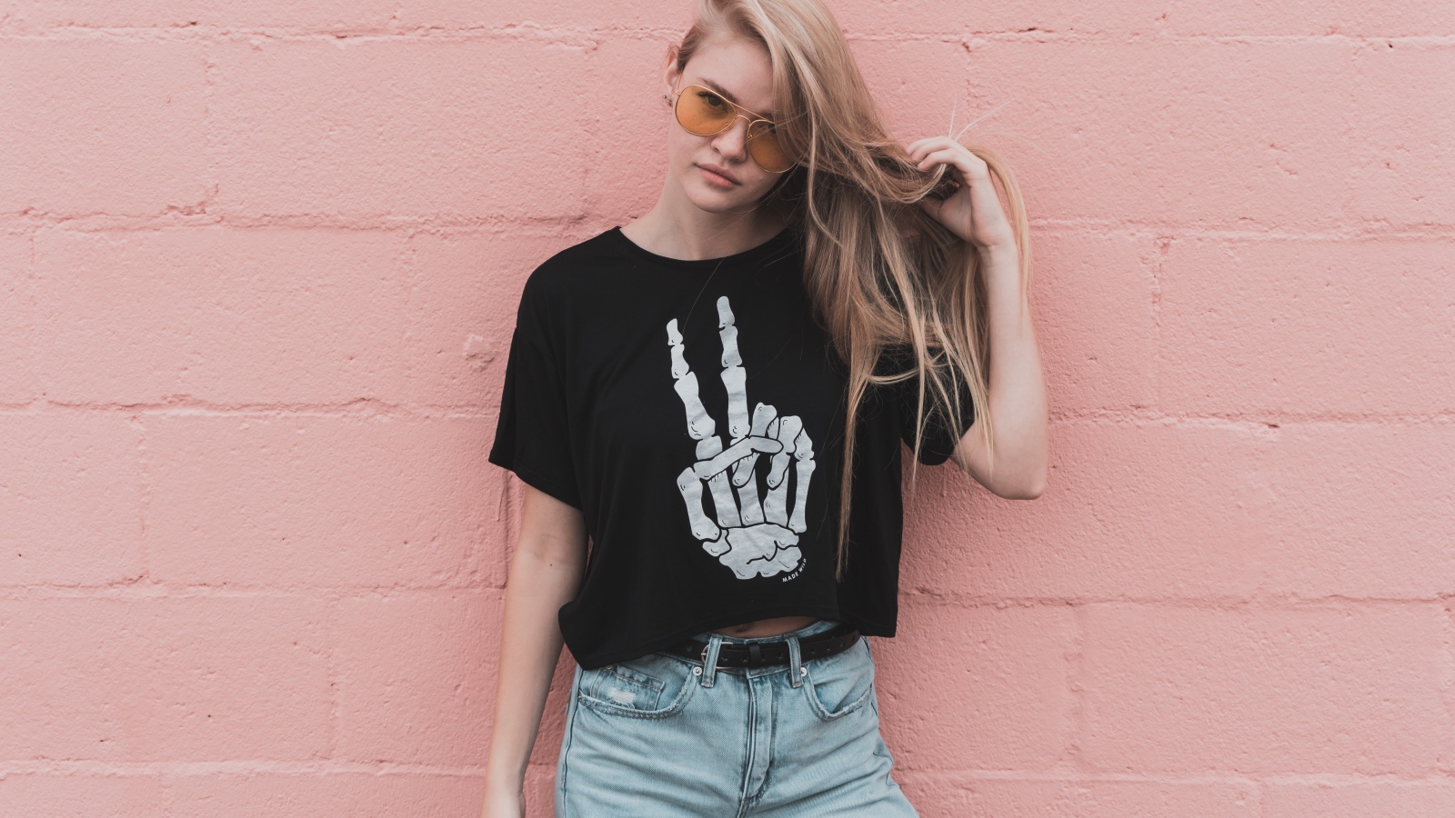 Красивая девушка стоит у розовой стены 