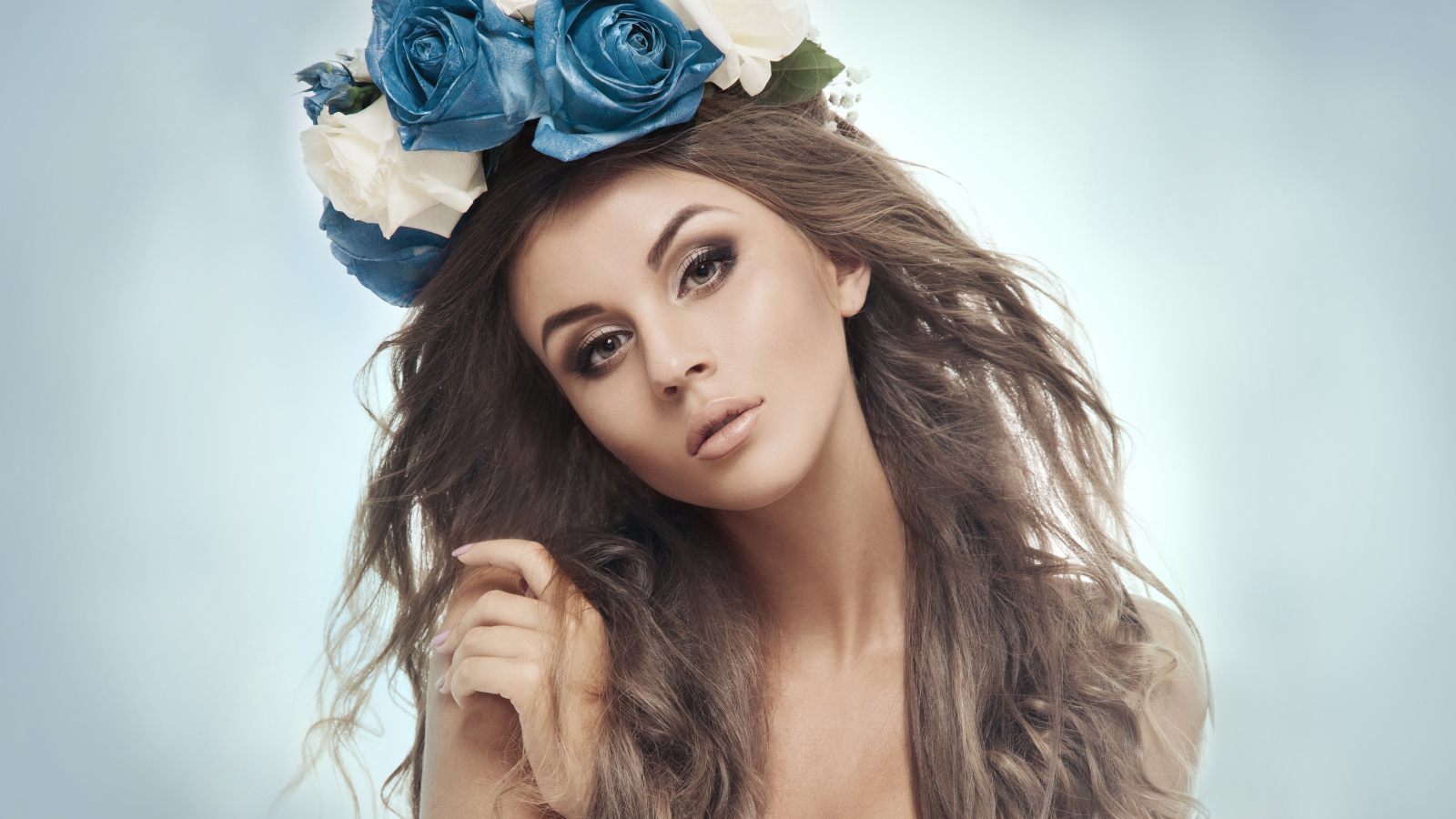 Красивая девушка с венком на голове на сером фоне