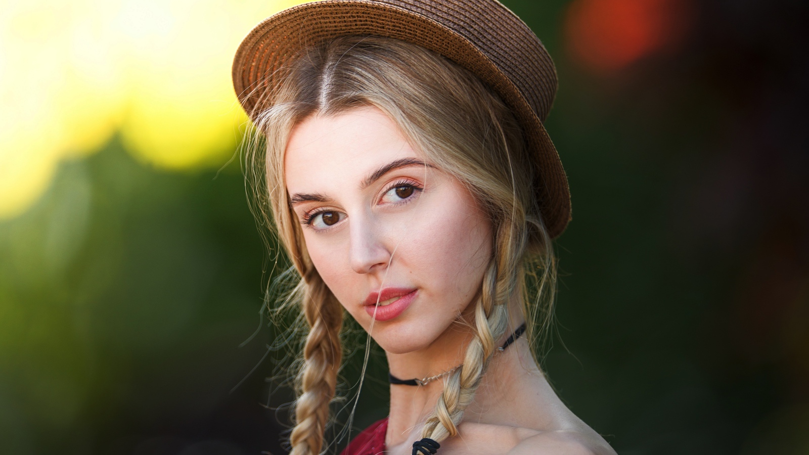 Кареглазая девушка с косами на голове в шляпе