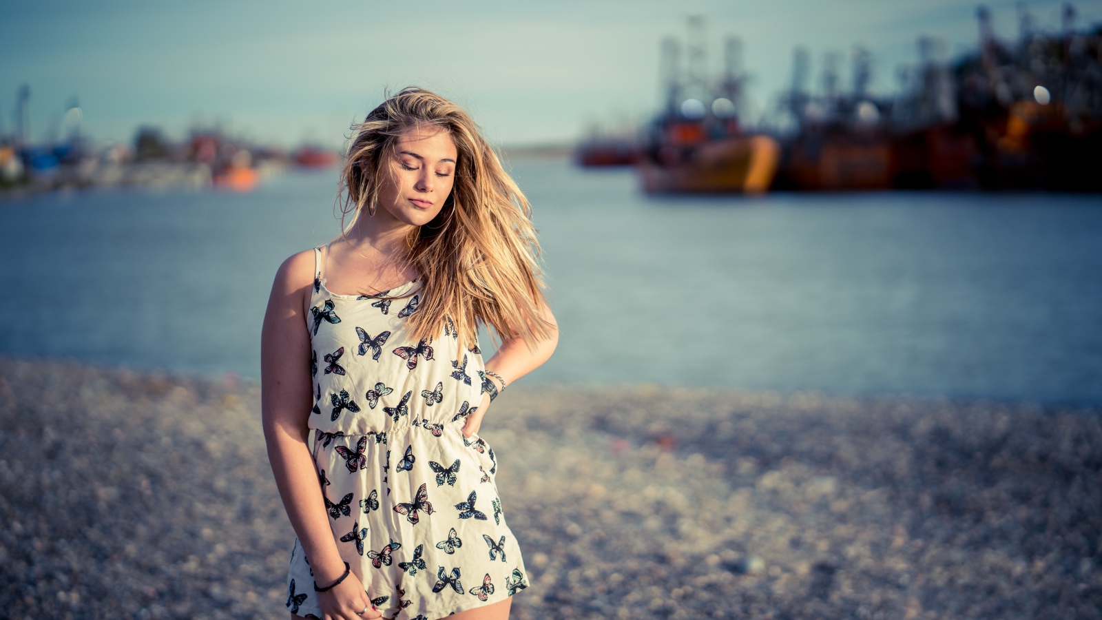 Милая блондинка на фоне моря в порту
