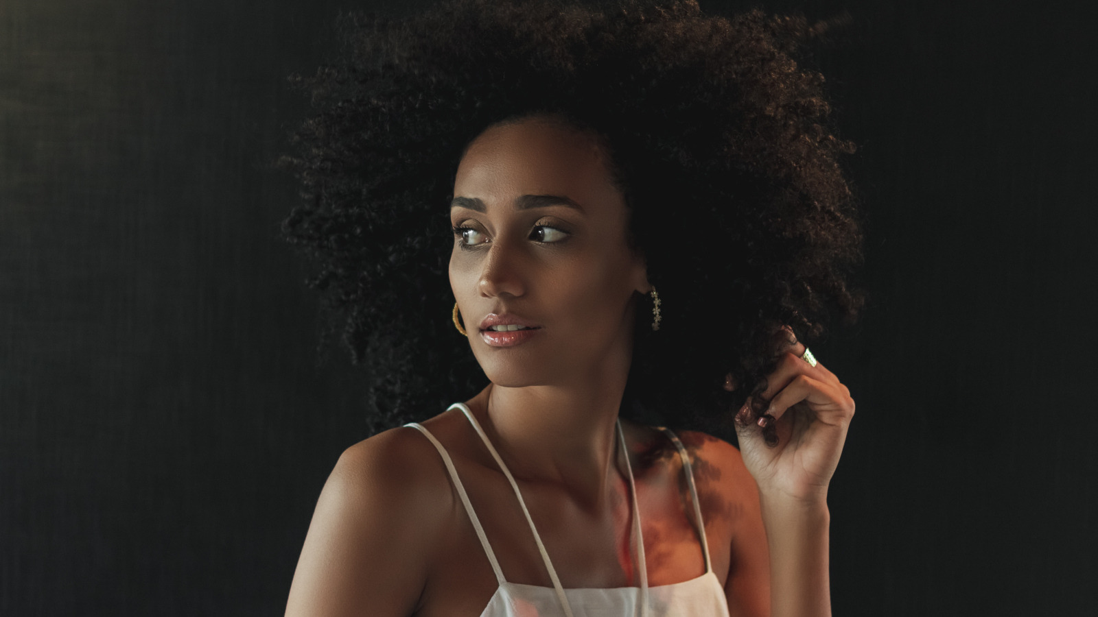 Темнокожая девушка с красивыми волосами на сером фоне