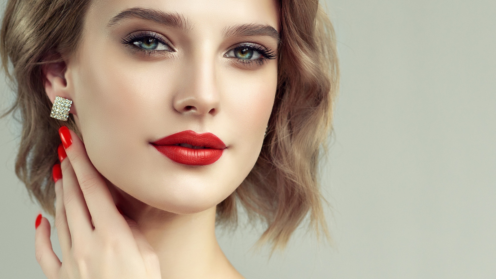 Лицо девушка с красивым макияжем на сером фоне