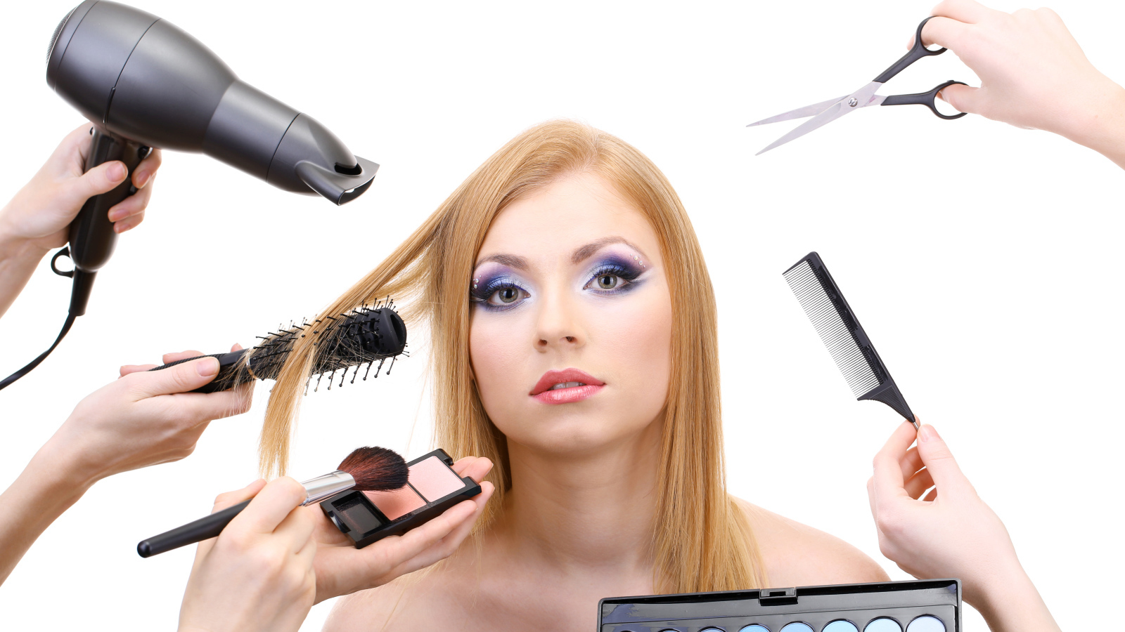 Девушке делают макияж и прическу на белом фоне