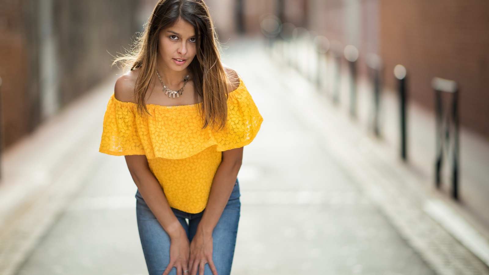 Девушка в джинсах стоит на улице 