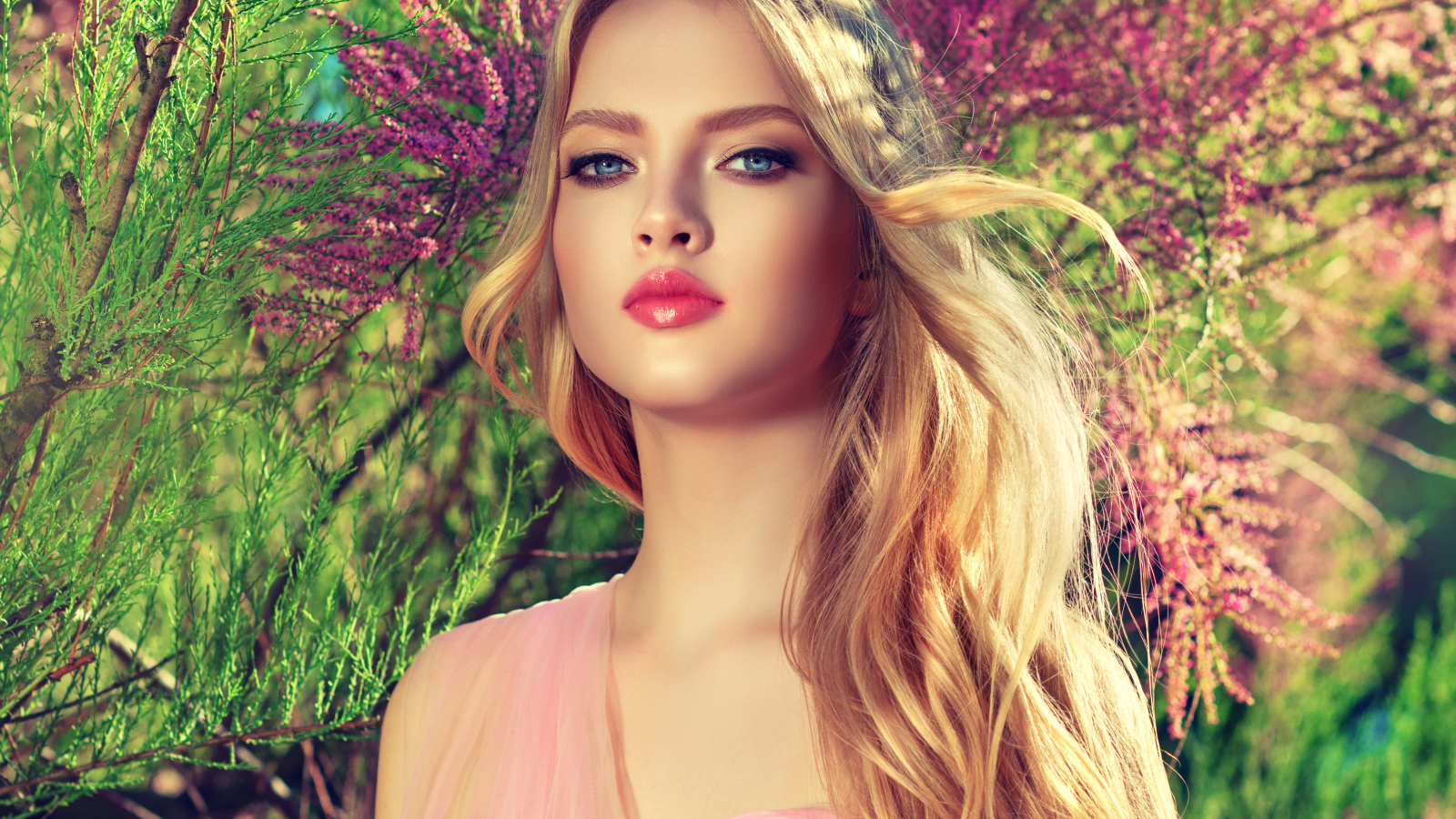 Девушка с красивыми голубыми глазами у цветущего дерева