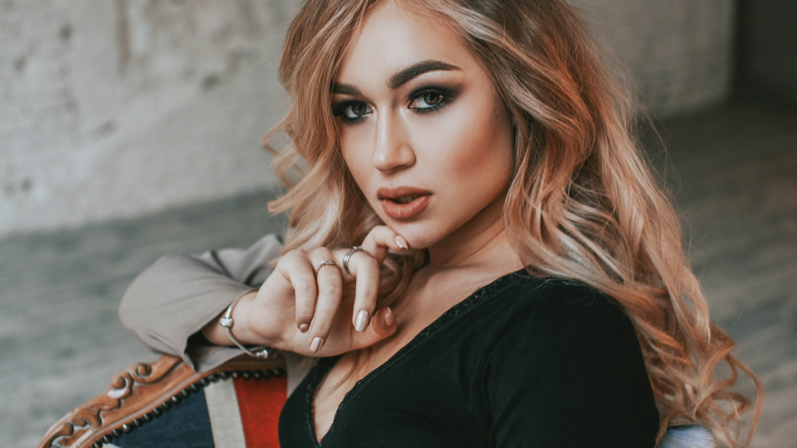 Горячая девушка с макияжем сидит на стуле