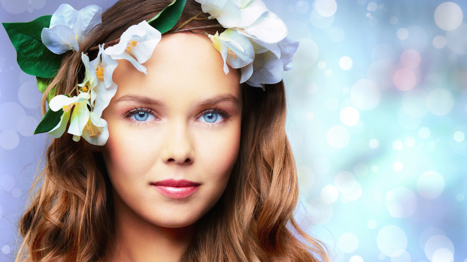 Нежная голубоглазая девушка с цветами в волосах 