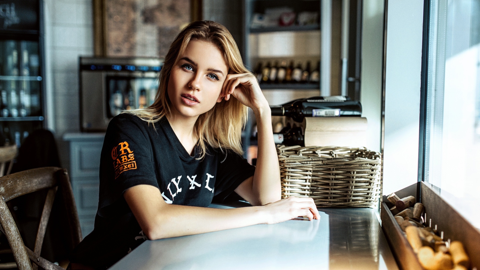 Молодая голубоглазая девушка сидит в кафе