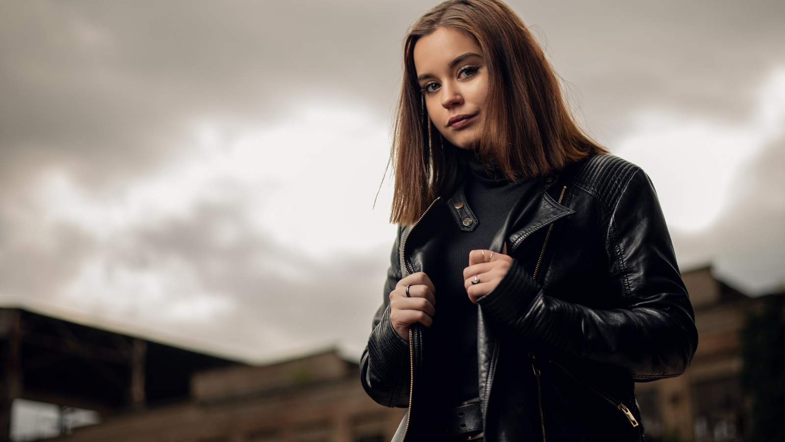 Молодая девушка в кожаной куртке на фоне грозового неба