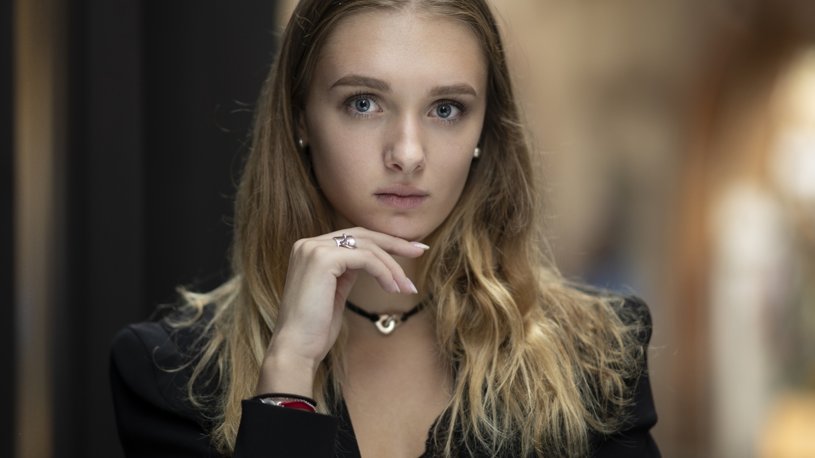 Молодая нежная голубоглазая девушка с рукой у лица