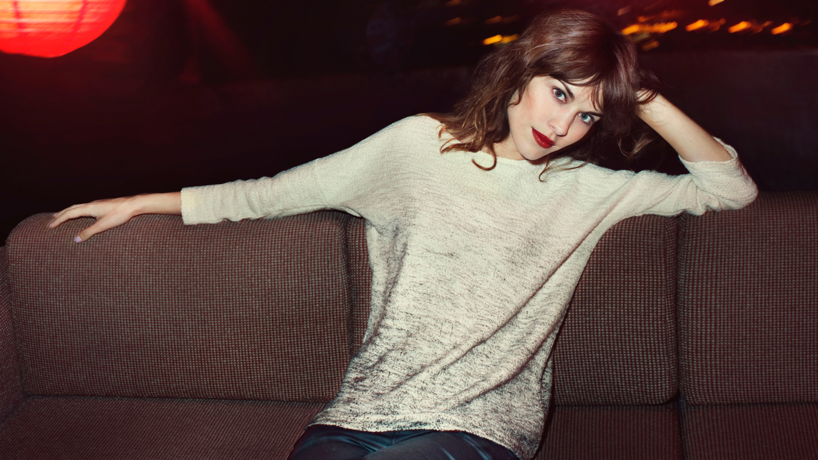 Красивая девушка модель Алекса Чанг сидит на диване