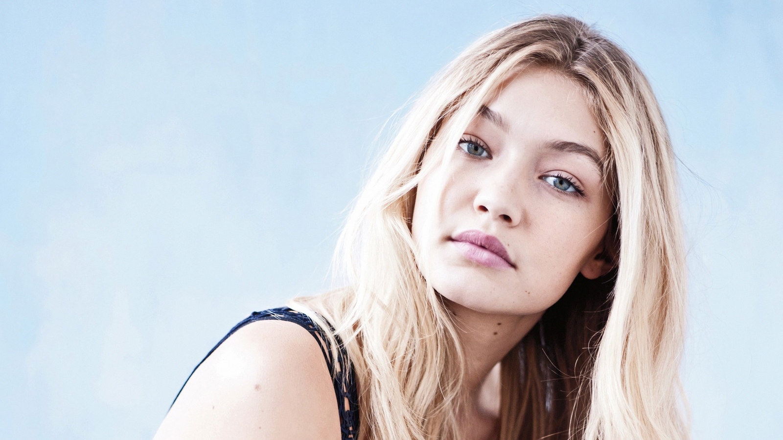 Молодая блондинка, модель Джиджи Хадид на сером фоне