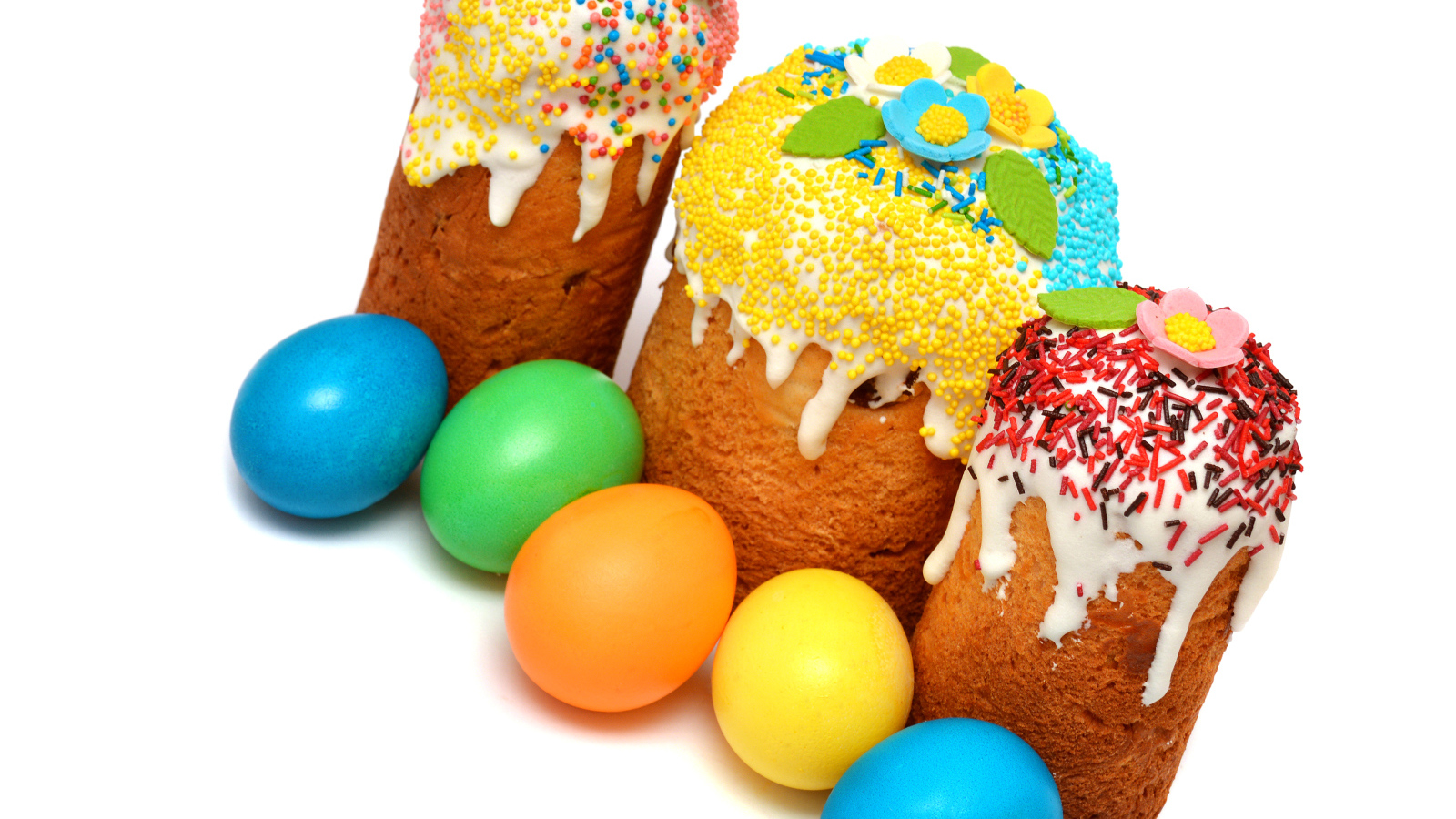 Три кулича с крашеными яйцами на белом фоне к празднику Пасха