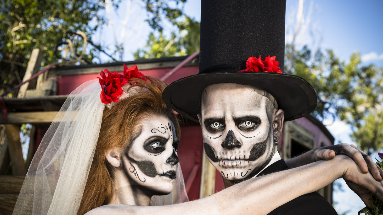 Пара жених и невеста с масками с грима на лице на Хэллоуин 