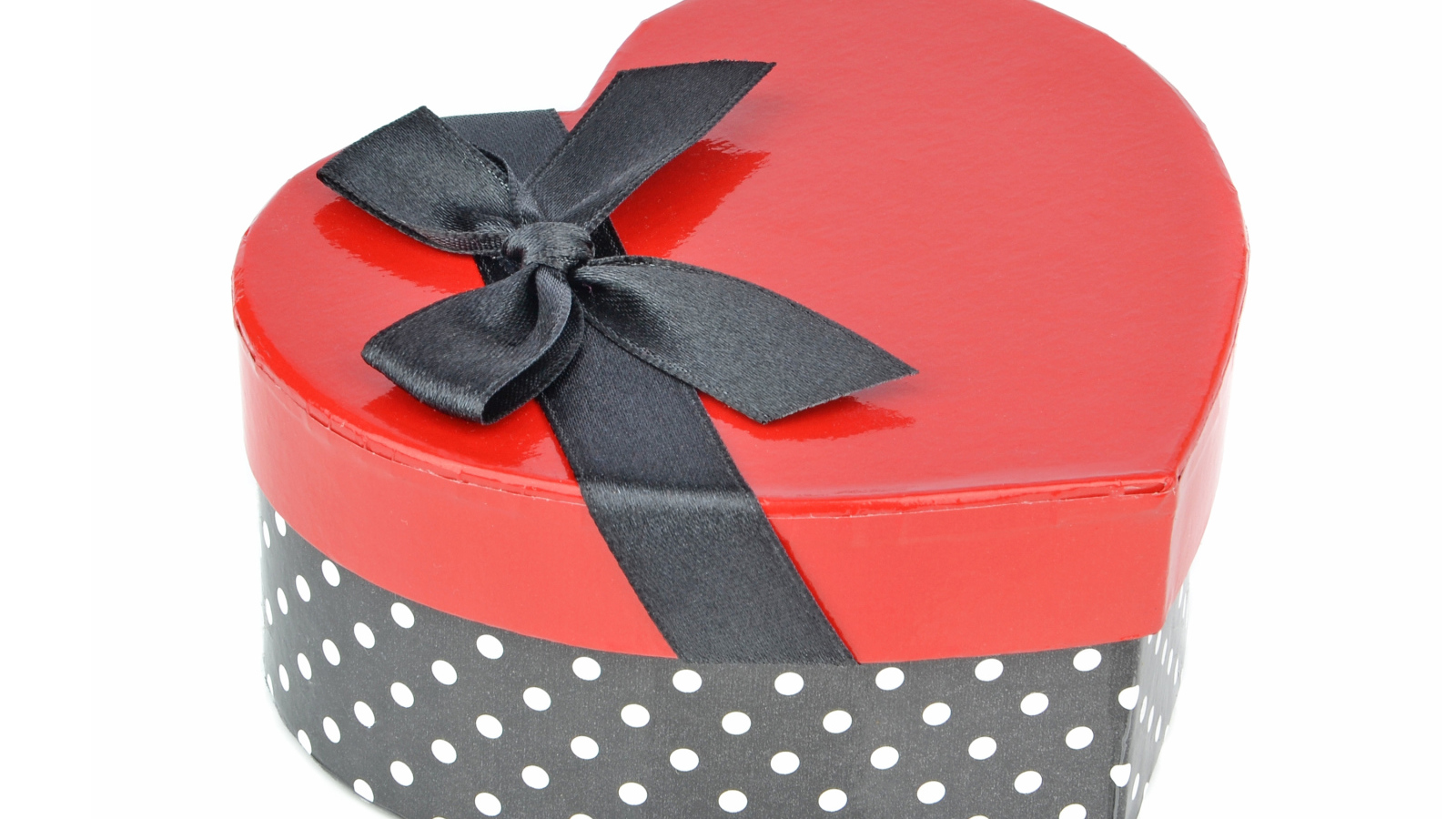 Красивая коробка в форме сердца с черным бантом на белом фоне