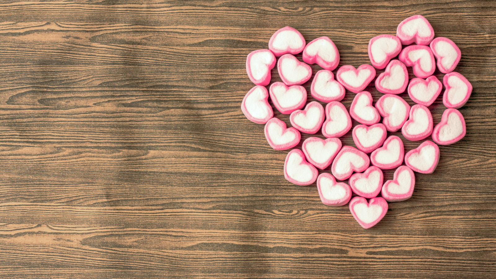 Сердце из конфет на деревянном столе