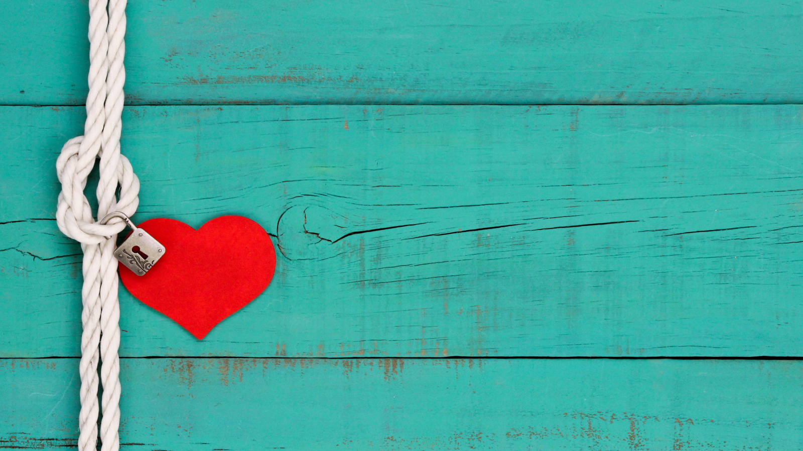 Красное сердечко на веревке с замком на голубом фоне