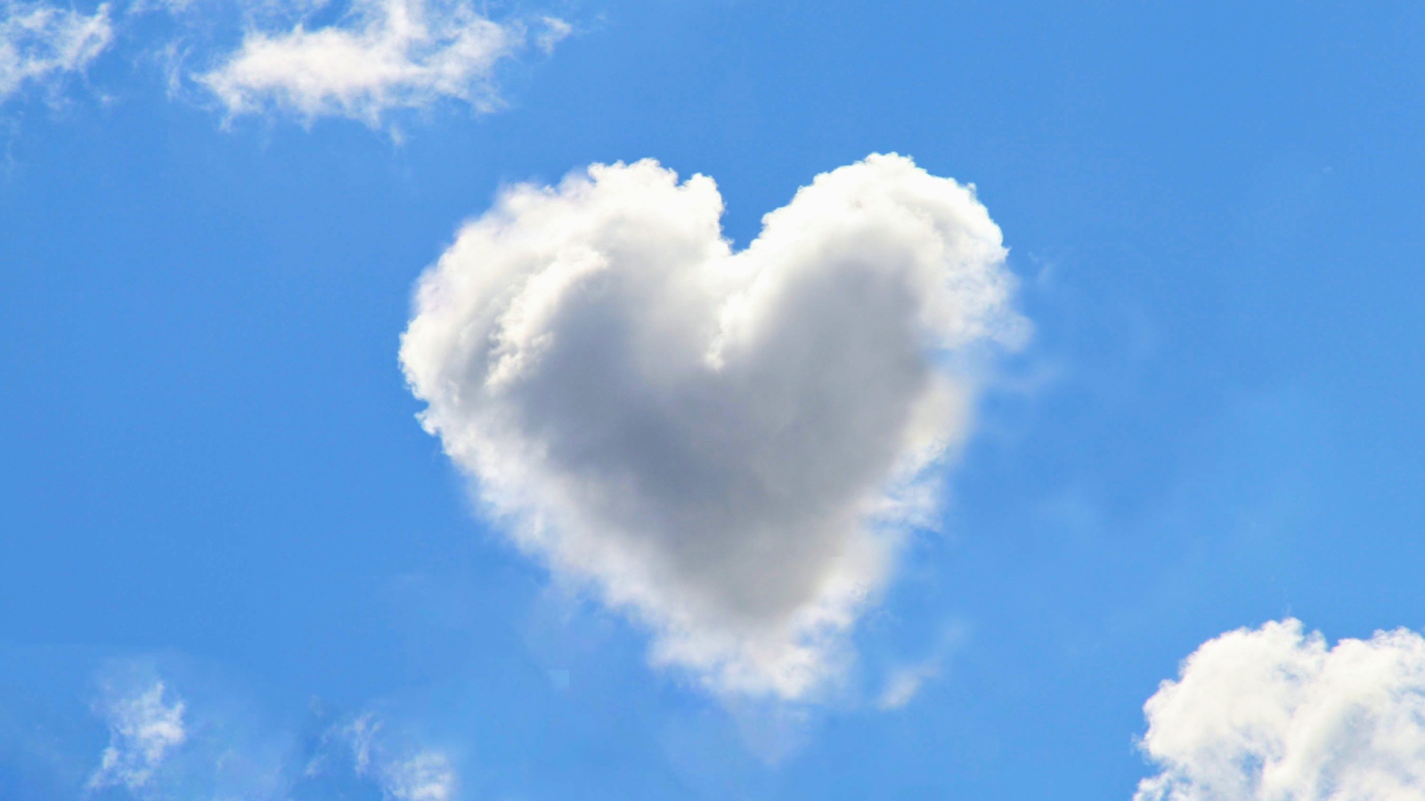 Белое облако в форме сердца в голубом небе 