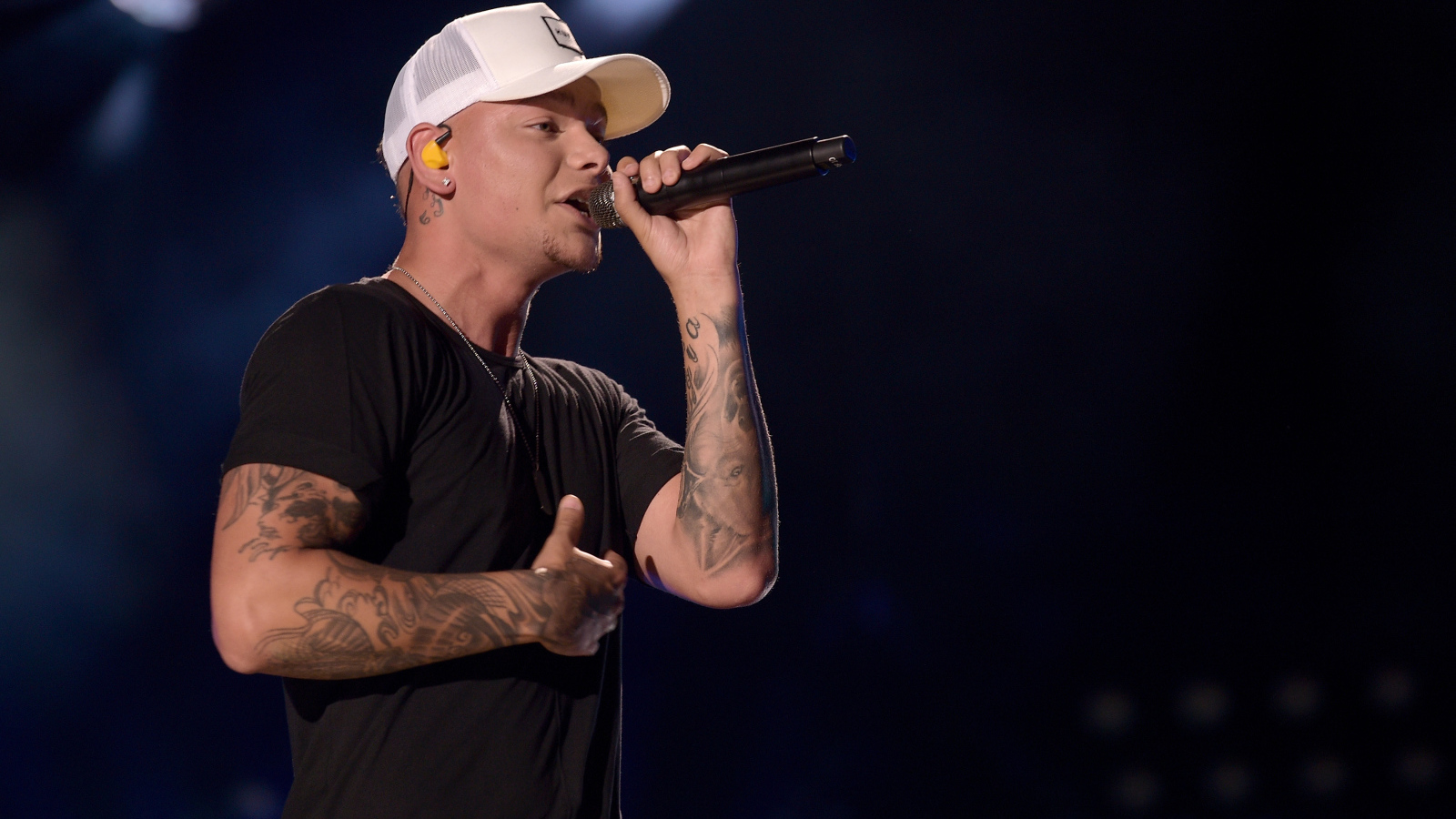 Американский кантри певец Кейн Браун с микрофоном на сцене