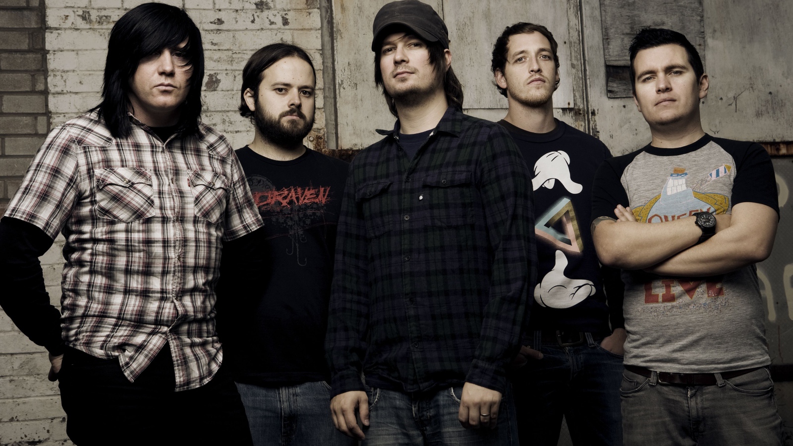 Музыкальная группа Funeral for a Friend стоят у старой стены