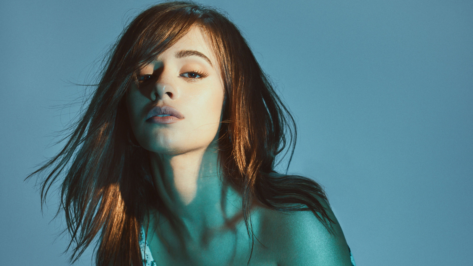 Молодая кареглазая певица Камила Кабельо на синем фоне