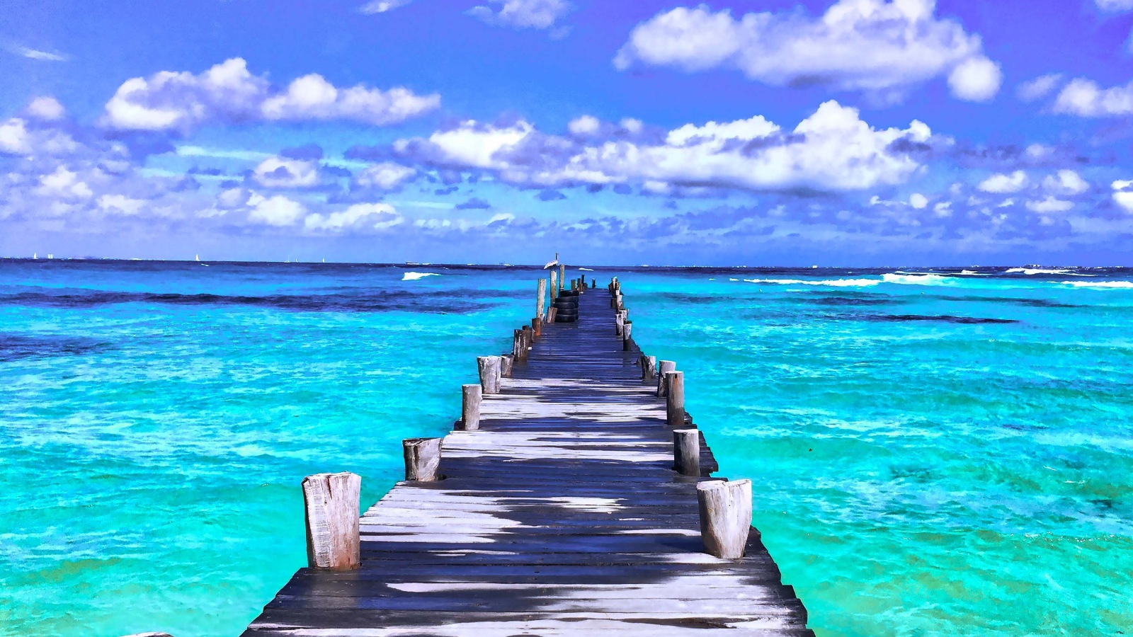 Деревянный мокрый пирс в голубом океане под красивым небом