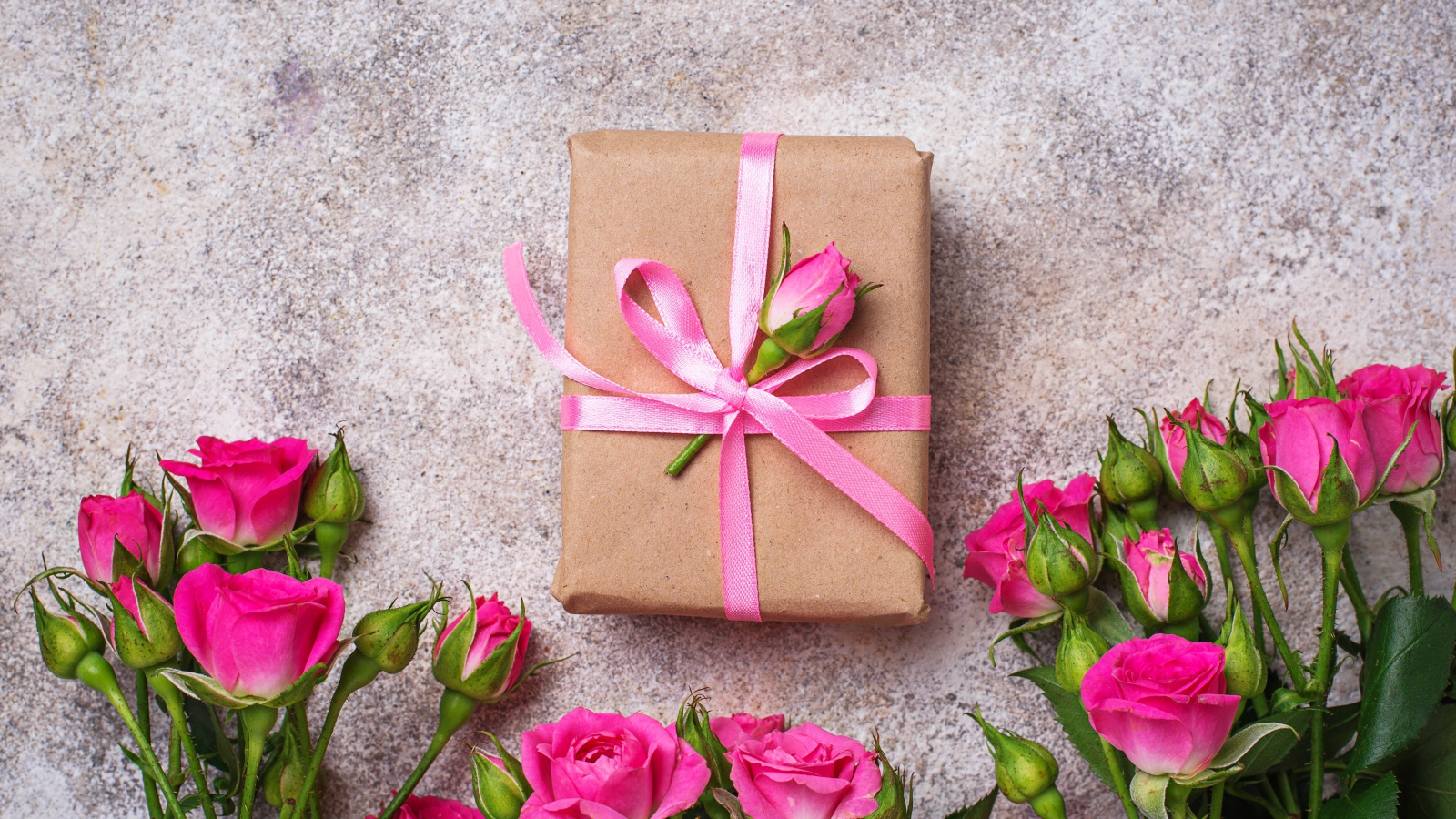 Подарок на сером фоне с букетом розовых роз