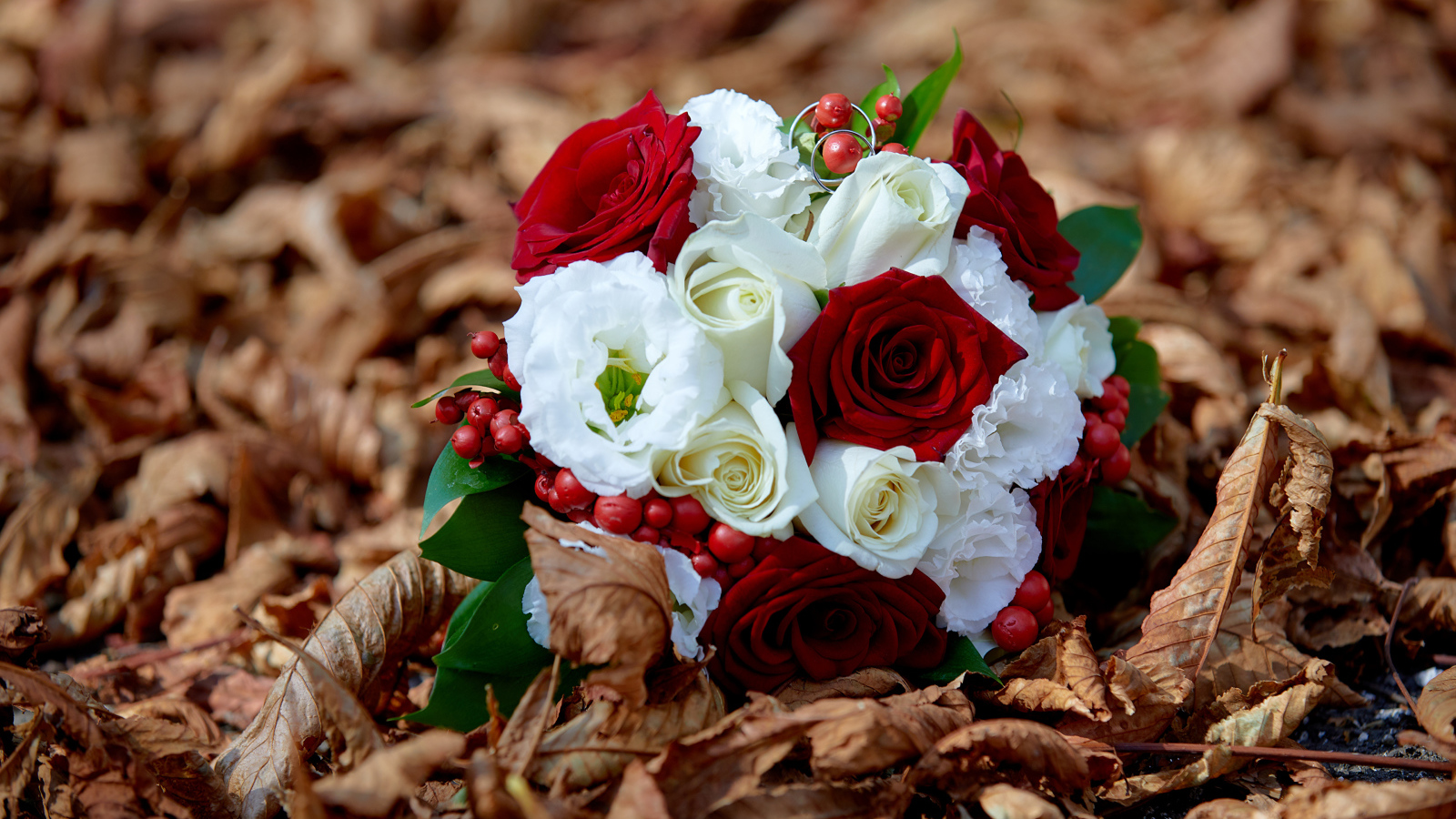 Красивый свадебный букет лежит на сухой траве