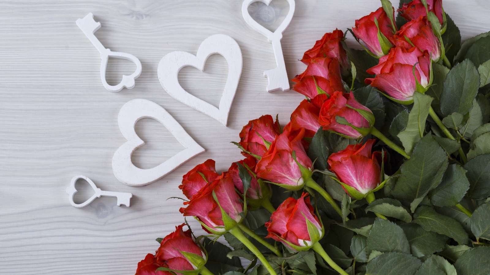 Букет красивых красных роз на серой поверхности с белыми сердечками  