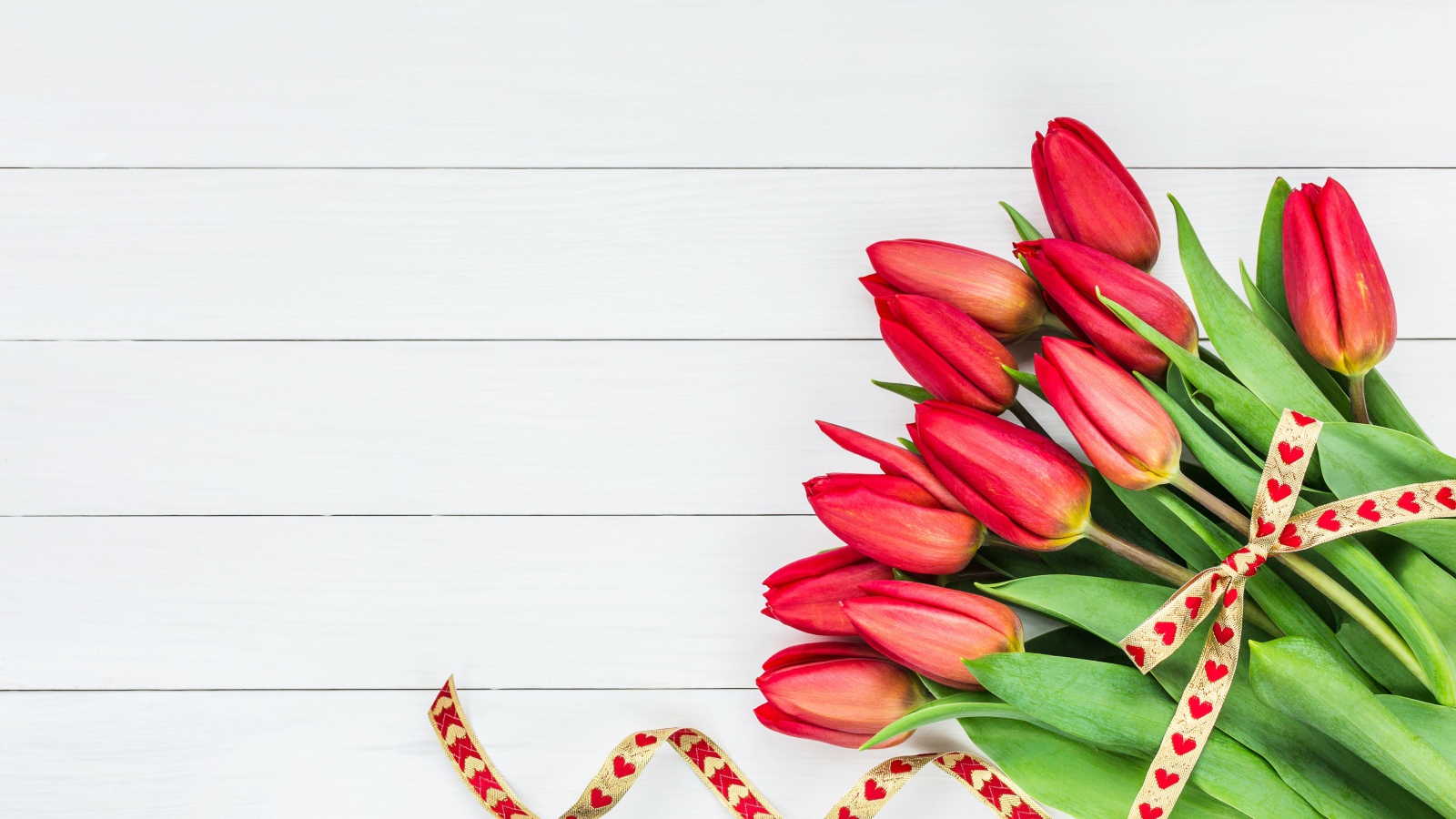 Букет красных тюльпанов с лентой на сером фоне