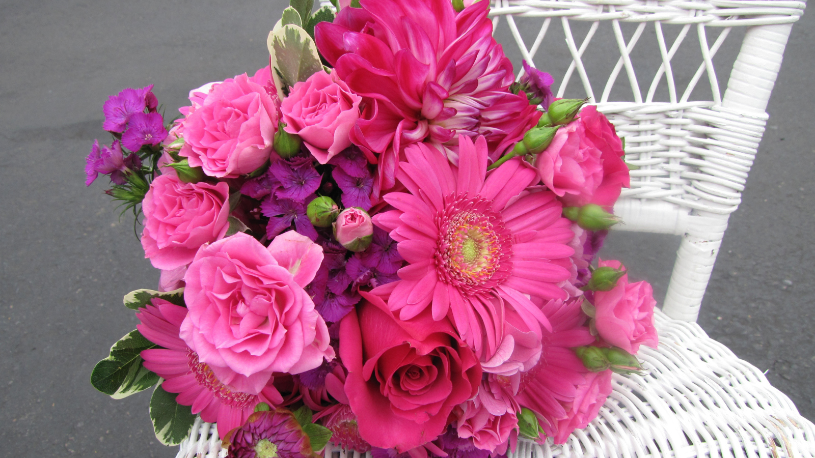 Букет с розовыми цветами георгины, розы, герберы и флоксы на белом стуле