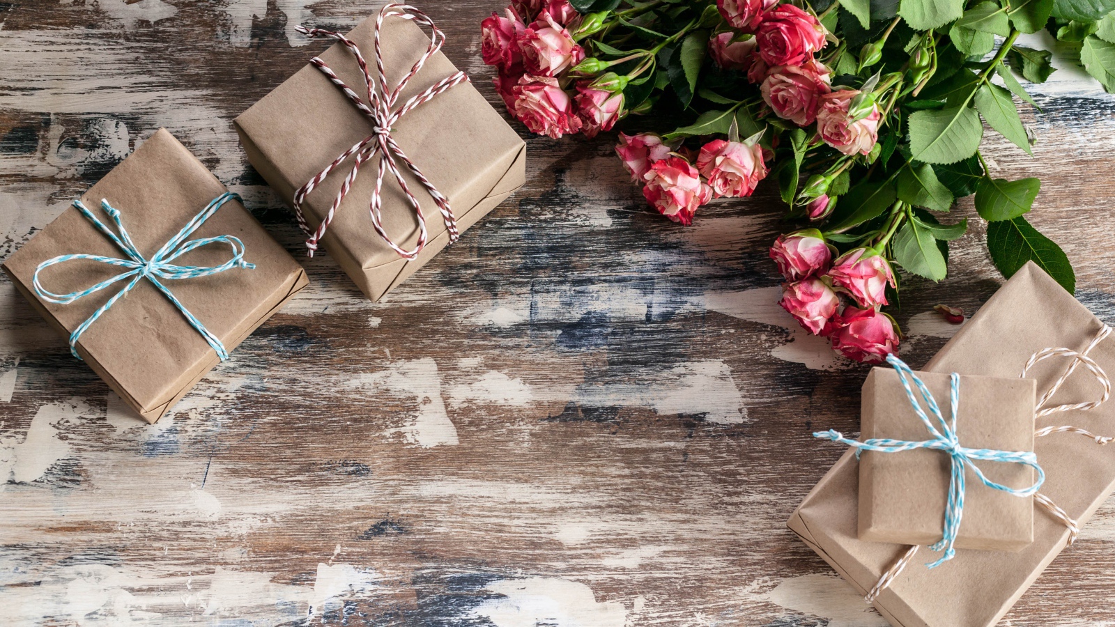Подарочные коробки на деревянной поверхности с букетом роз