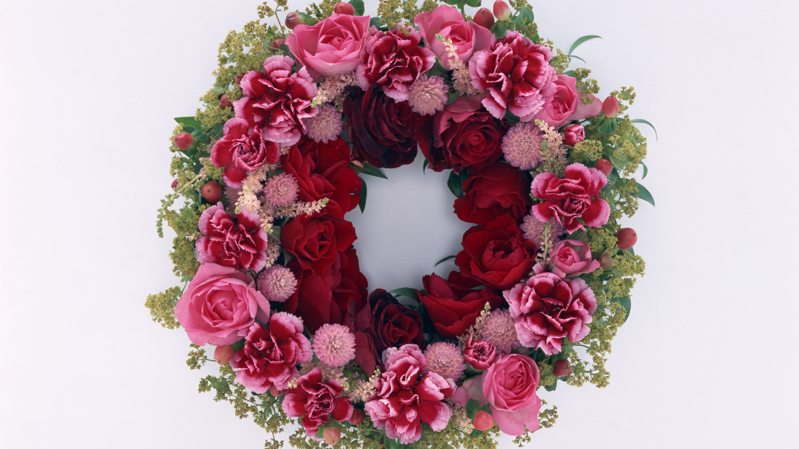Wreath and red roses with carnation flowers on a gray background