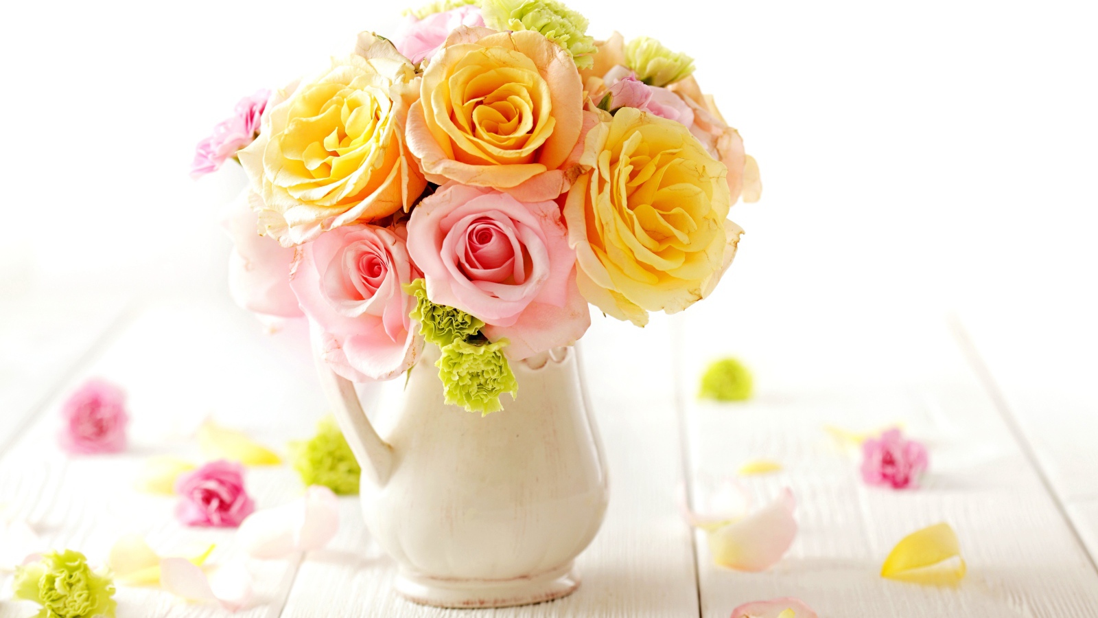 Желтые и розовые розы в вазе на столе 