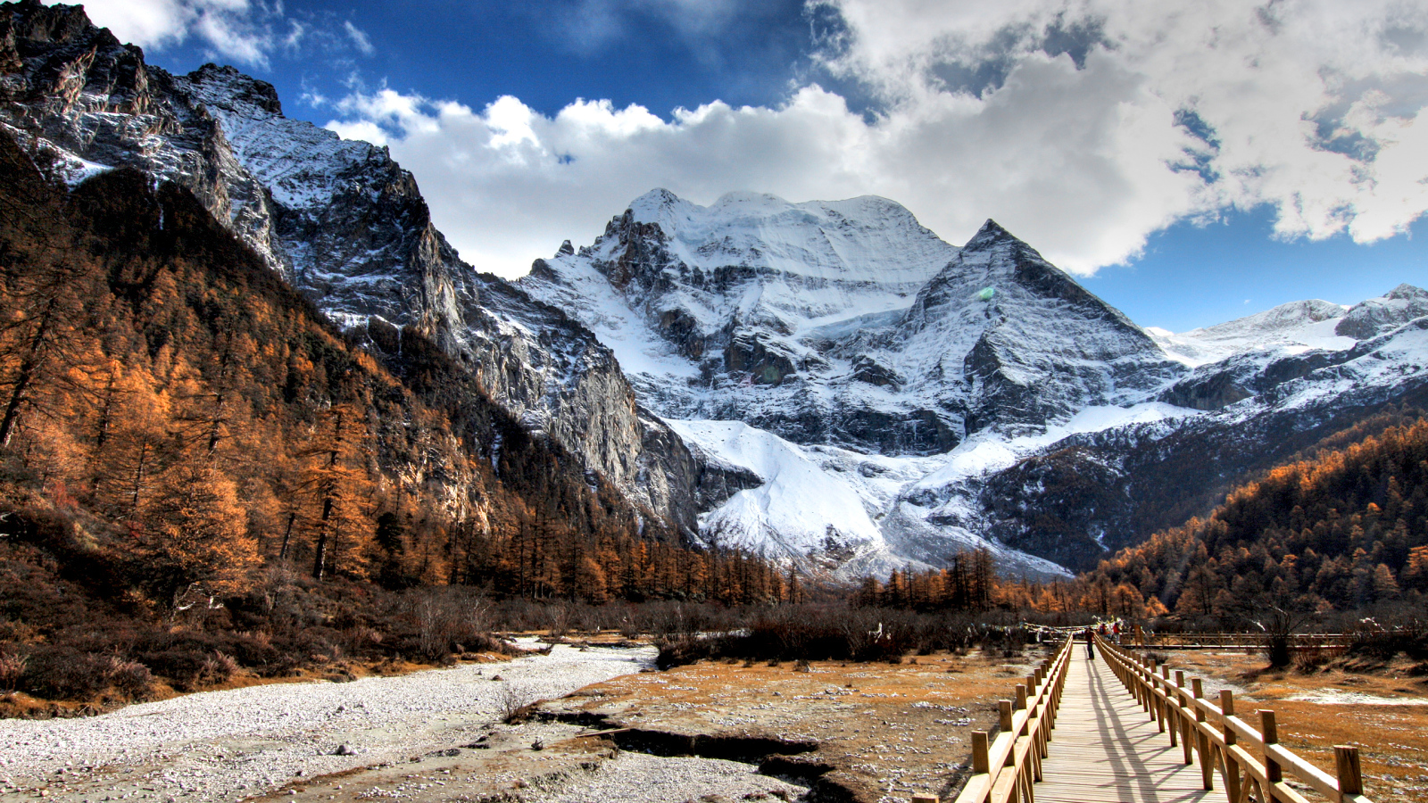 A bridge at the foot of snowy majestic mountains