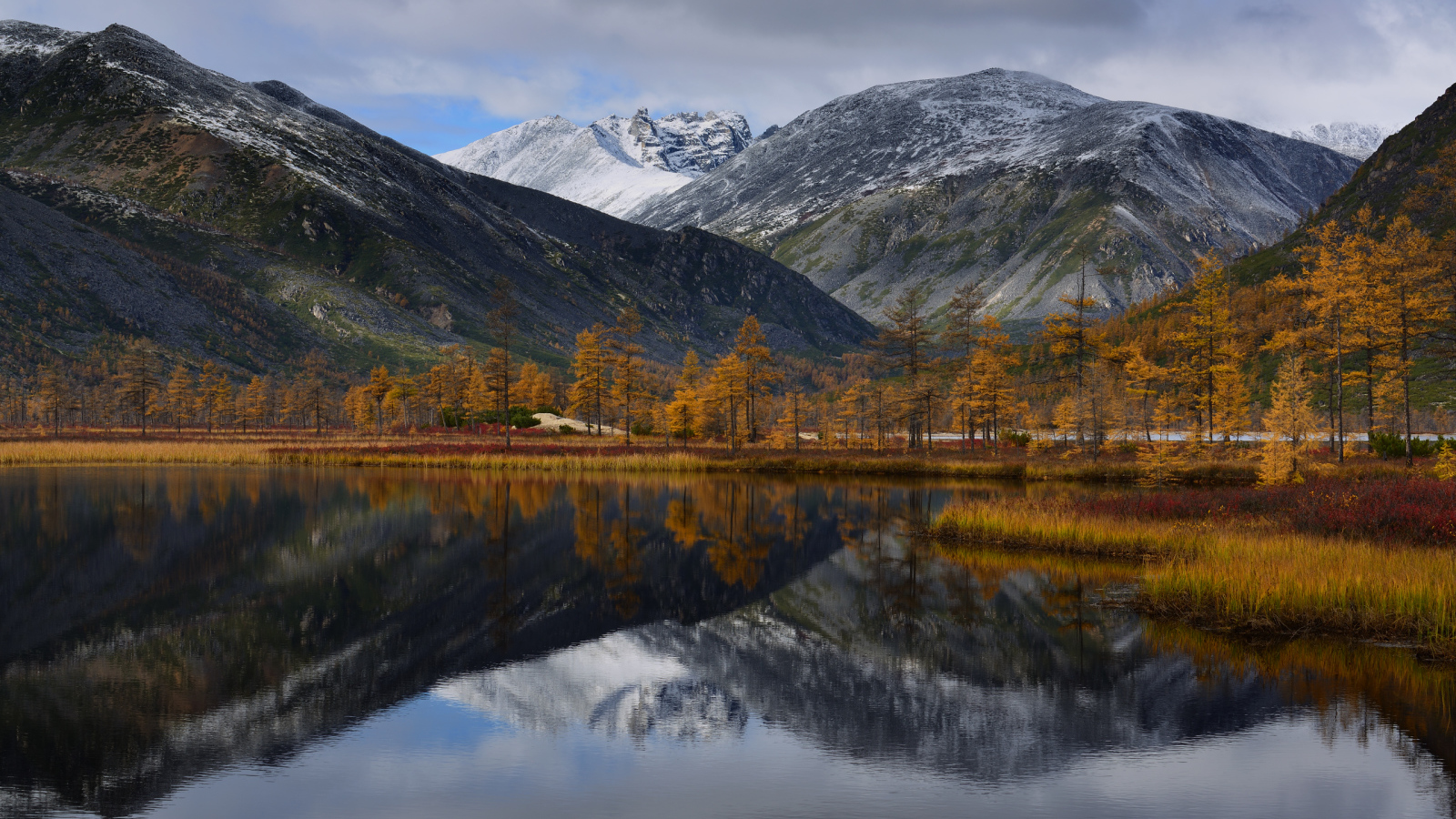 Горы отражаются в глади воды озера осенью