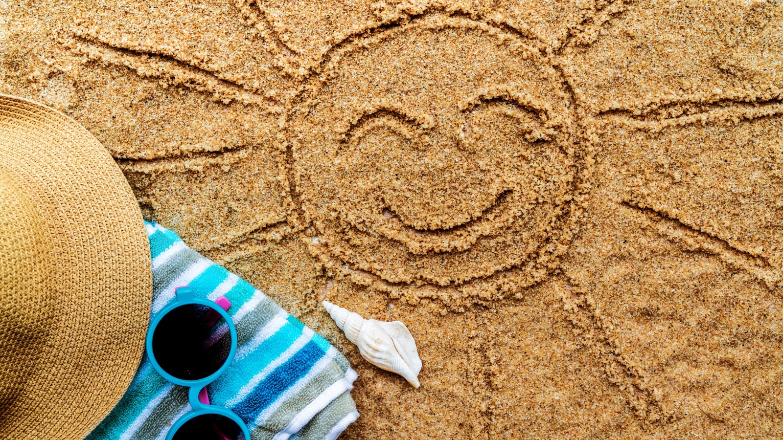 Солнце на песке с шляпой и полотенцем летом