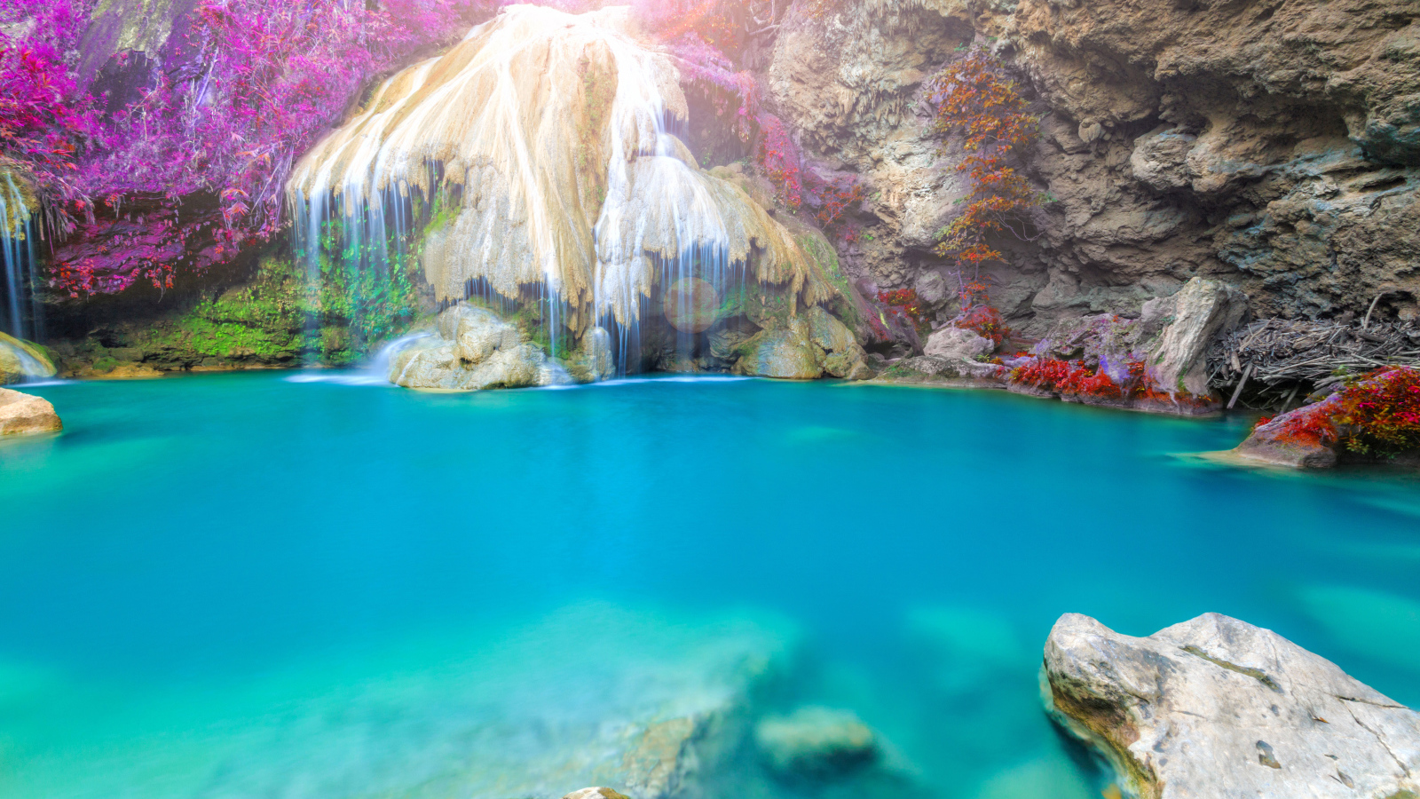 Водопад стекает по скале в голубую воду, Тайланд