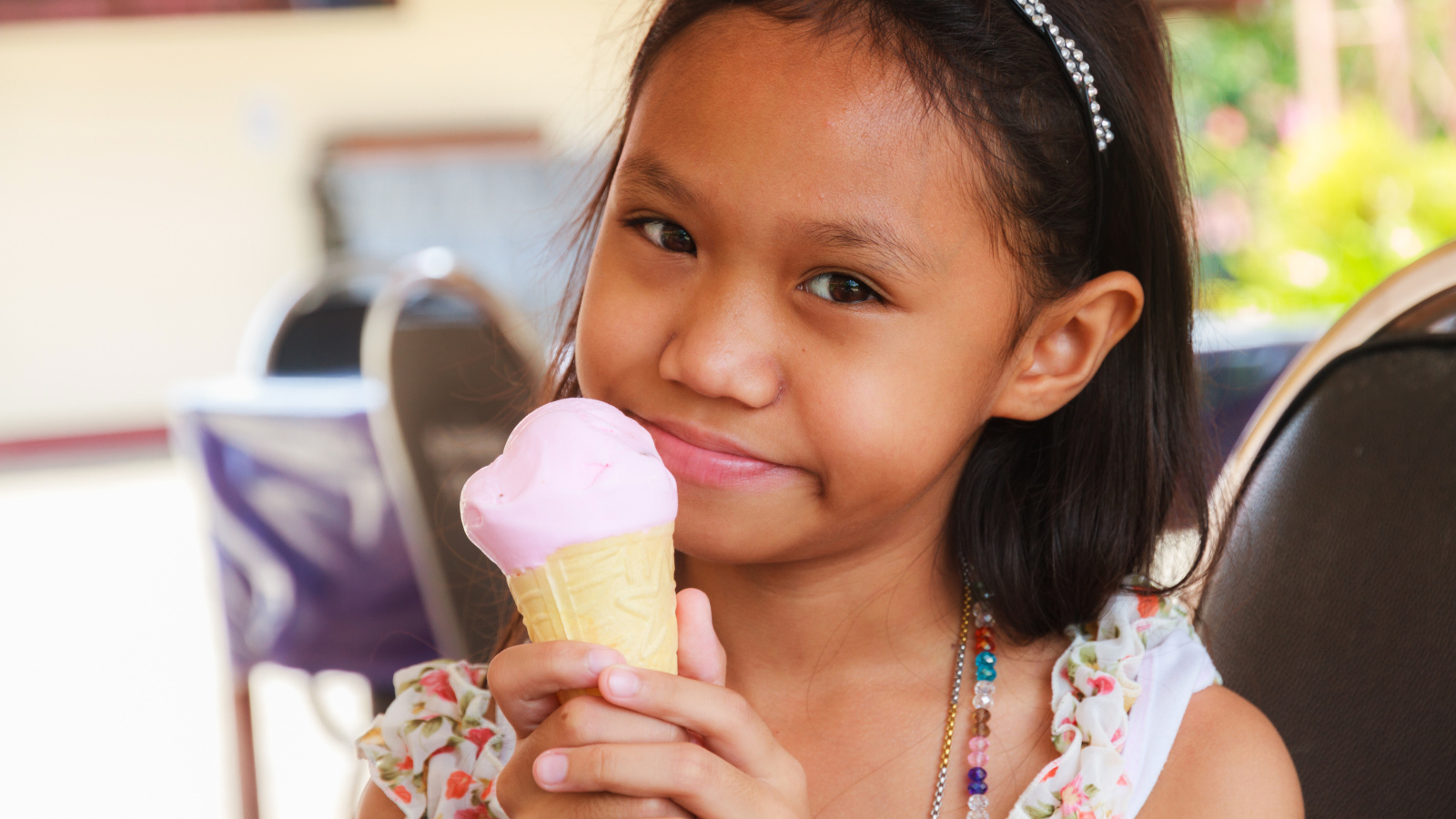 Маленькая девочка азиатка с мороженым в руке