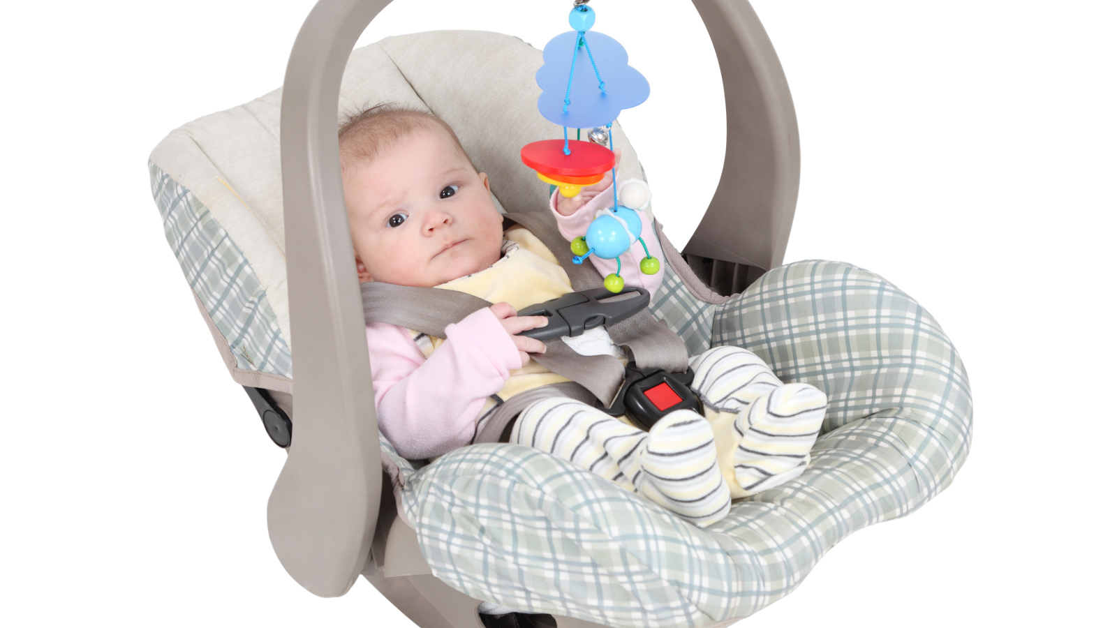 Маленький грудной ребенок в автомобильном кресле на белом фоне